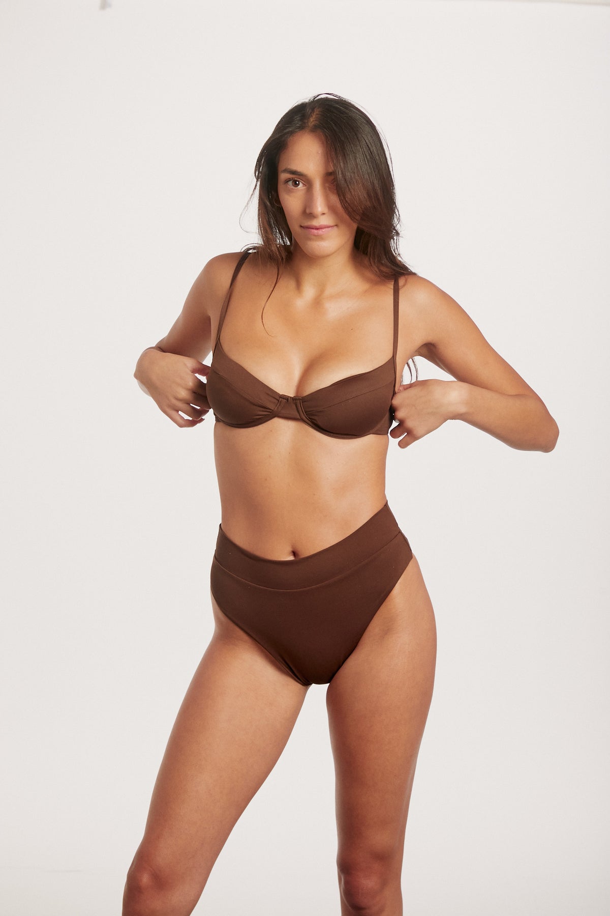 Woman wearing a brown bikini set on a white background