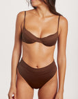 Woman wearing a brown bikini set on a white background