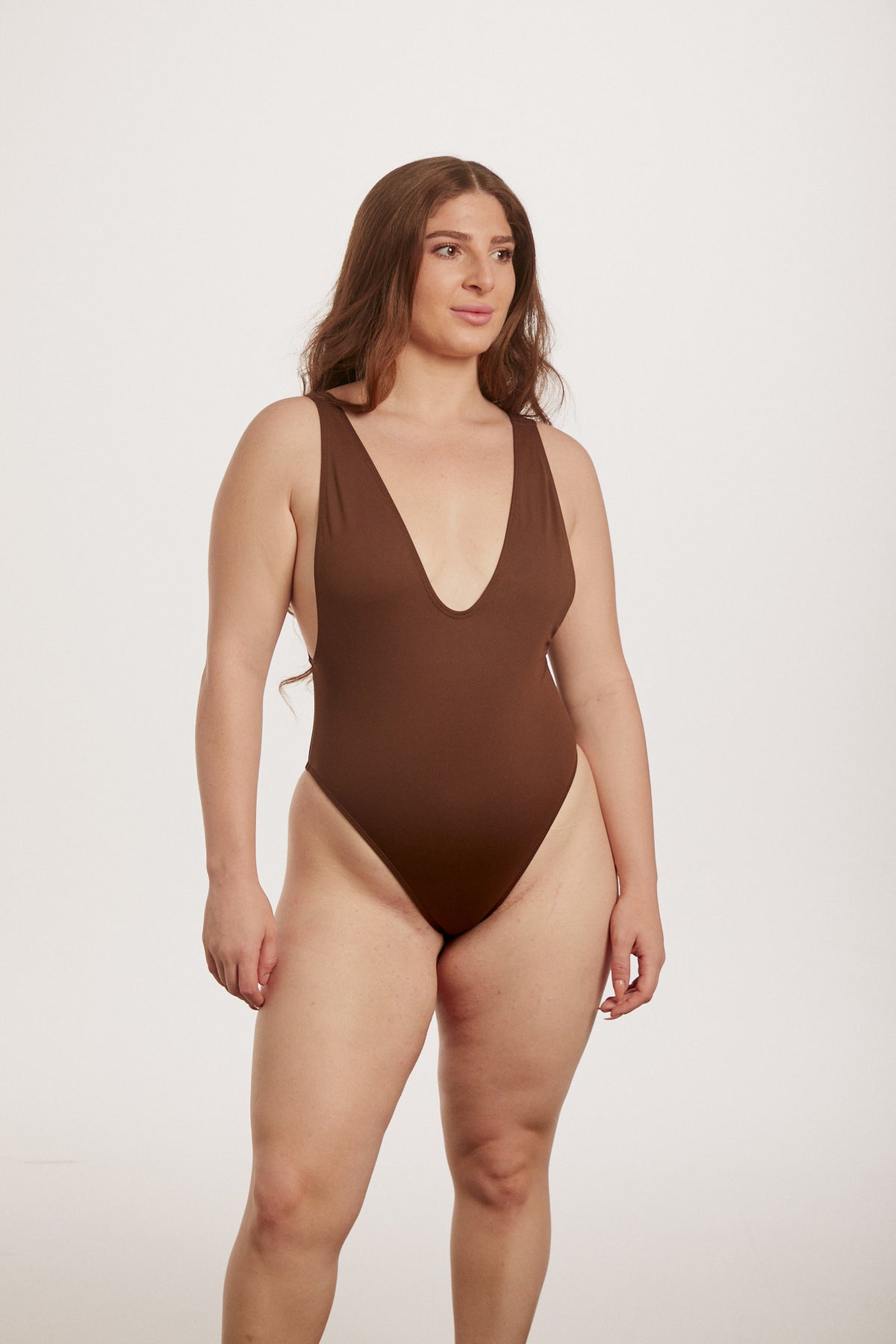Woman wearing a brown swimsuit on a white background