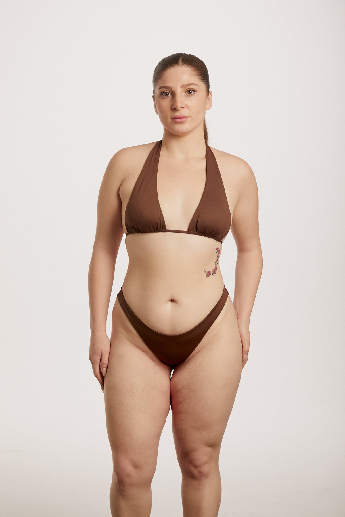 Woman wearing a brown bikini against a white background