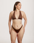 Woman wearing a brown bikini against a plain background