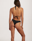 Woman wearing a black bikini on a white background