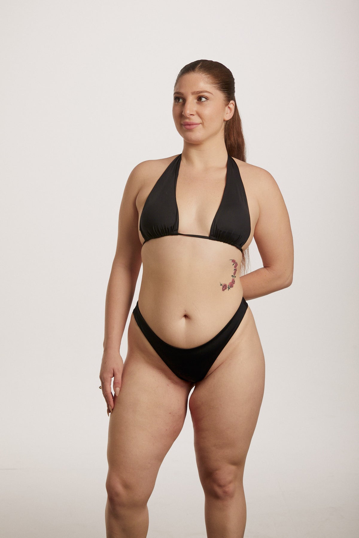 Woman wearing a black bikini against a plain background